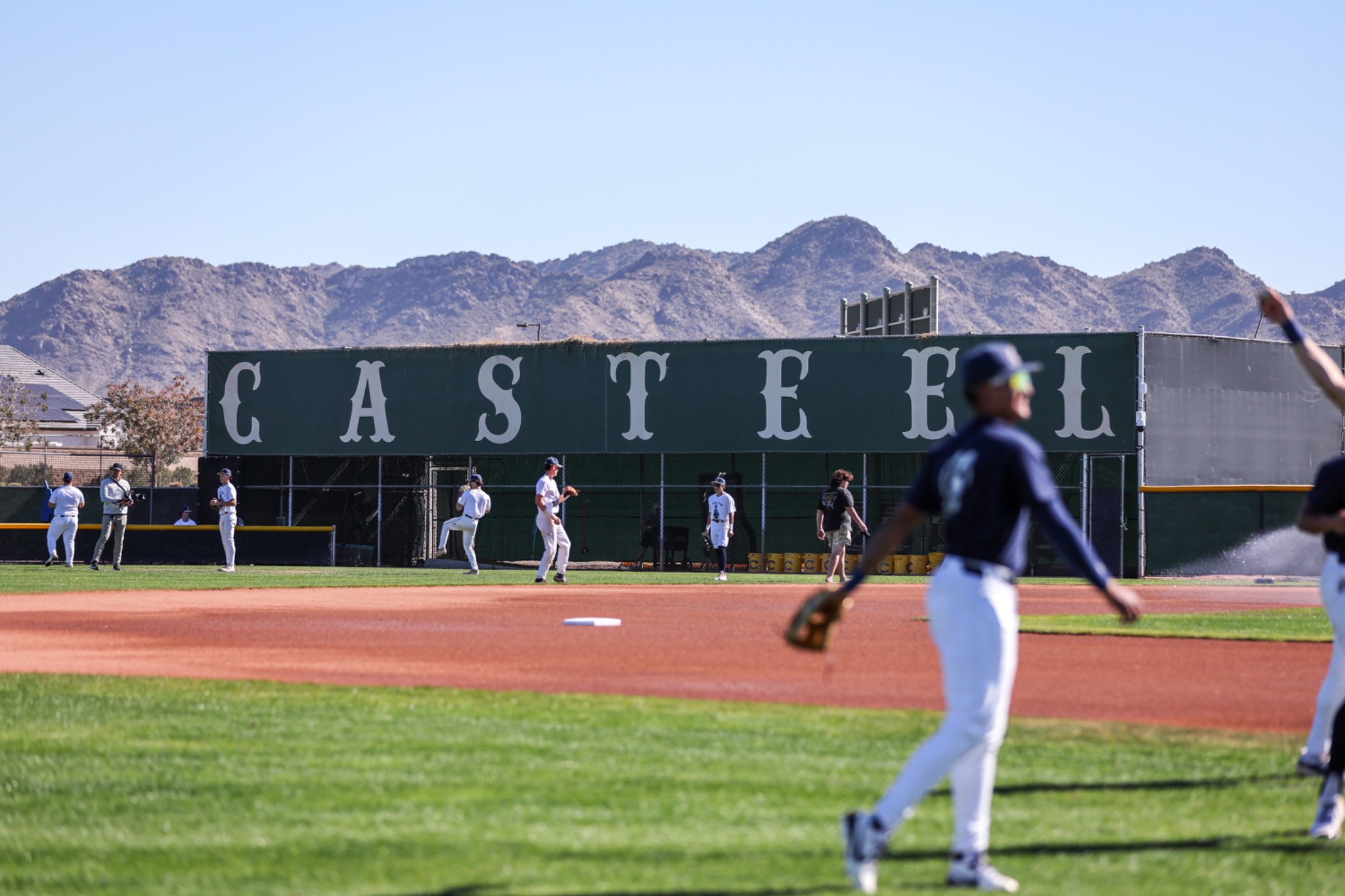 Casteel Baseball players warming up at Colt Field with the San Tan Mountains behind them