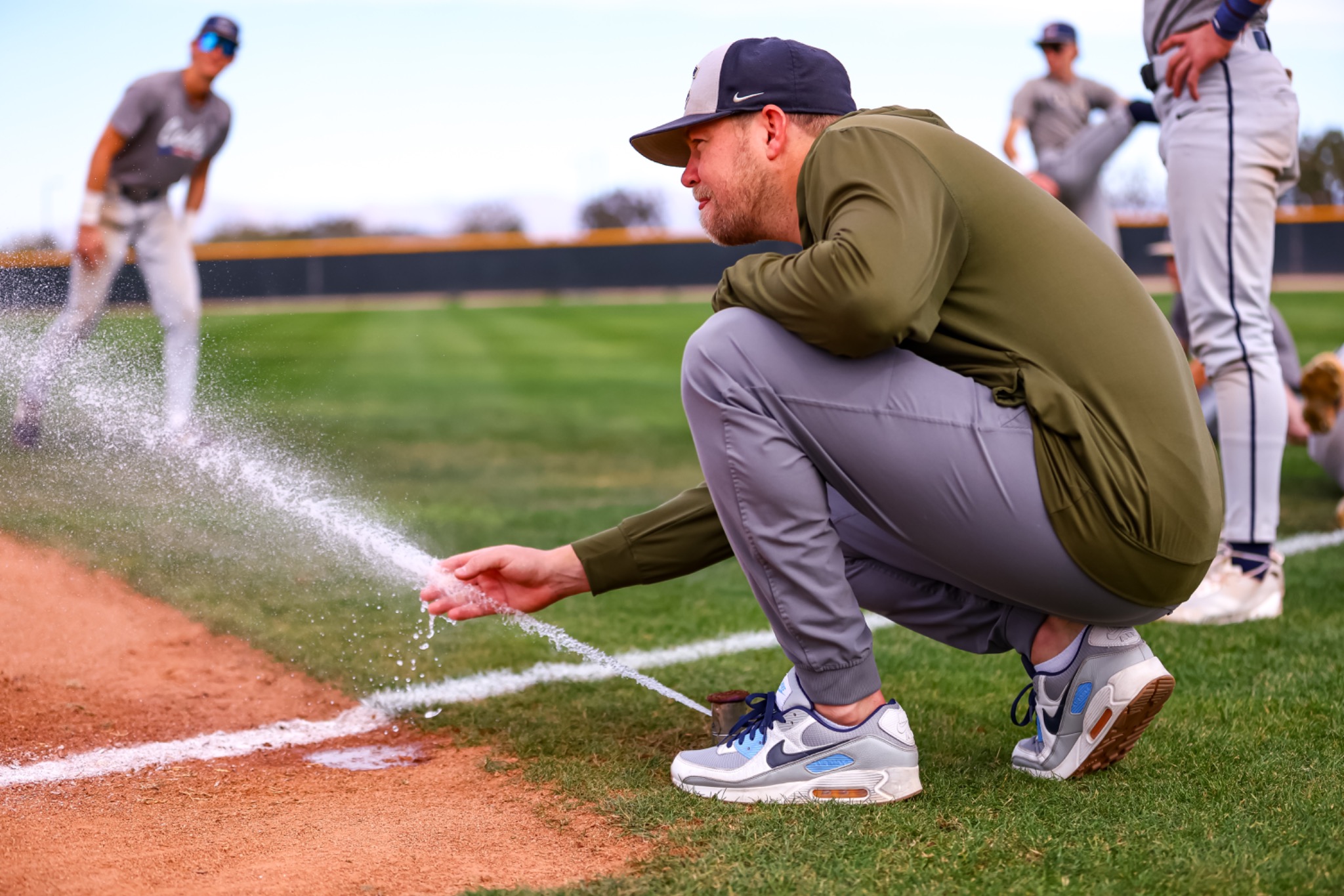 Casteel coach tending the field line with players behind him