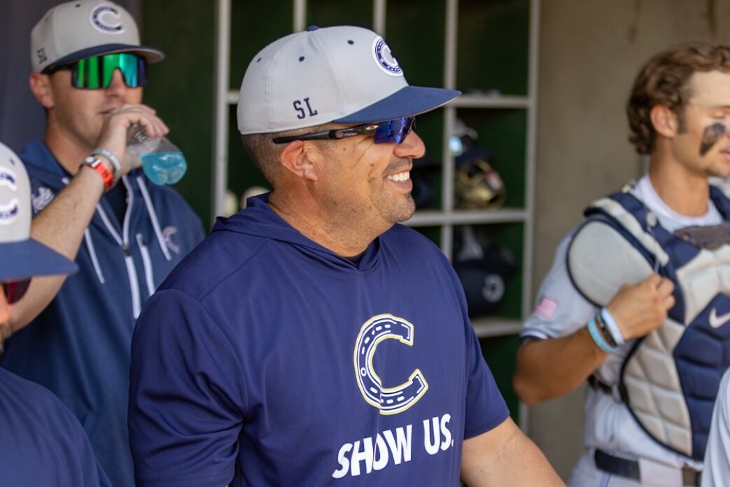 Casteel coach smiles in the dugout before the game