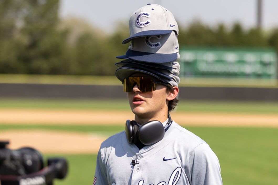 Casteel player wearing a stack of team hats before the game
